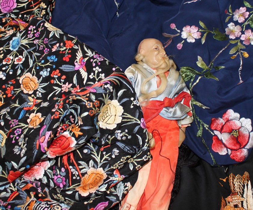 A collection of Chinese textiles and an oriental doll