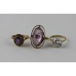 A 9ct. gold and amethyst ring, having central oval cut amethyst in rub over setting surrounded by