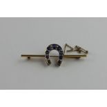 A yellow metal, diamond and sapphire "horseshoe" bar brooch, having yellow metal horseshoe mount set