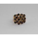 A yellow metal and sapphire dress ring, having rope work lattice set eighteen round cut