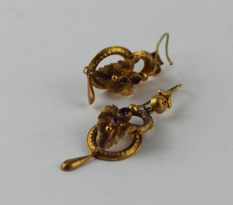 A cased pair of yellow metal and amethyst drop earrings, fashioned as two conjoined rings below a - Image 3 of 3