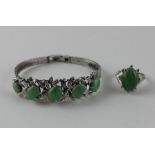 A 14ct. white gold and jade ring, the raised centre four claw set oval cabochon apple green jade