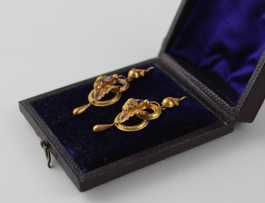 A cased pair of yellow metal and amethyst drop earrings, fashioned as two conjoined rings below a - Image 2 of 3