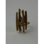 An 18ct. yellow gold asymmetric ring, of modernist design, fashioned as a double stylised 'H' motif,