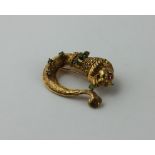 An 18ct. yellow gold and emerald brooch,  fashioned as a stylised lion, the head with mane and