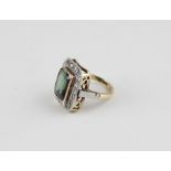 An 18ct. tourmaline and diamond cluster ring, having raised centre with large emerald cut tourmaline