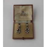 A pair of white metal, pearl and diamond drop earrings, the tear shape open work drops with