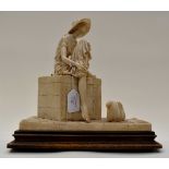 An Italian figurine of a girl on a packing case, dockside, in alabaster resin,