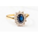 A Sapphire and diamond cluster ring set in 18 ct gold, set with an oval sapphire approx 1.