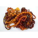 A quantity of amber and amber type necklaces, together with bracelets, brooches,