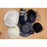 A collection of straw hats to include a Navy straw pillbox with a feather decoration and netting.