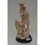 An early 19th century japanese carving in ivory of a man and a child walking across rocks