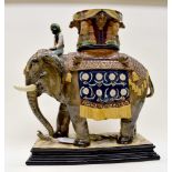 A Wilhelm Schiller & Sons Bohemia majolica elephant, standing on an oblong plinth base,