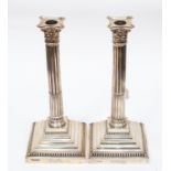 A pair of George V Corinthian column candlesticks, the base engraved with initials, Cooper Brothers,