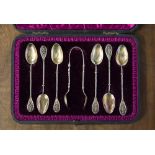 An early 20th Century boxed set of six silver teaspoons with sugar tongs,