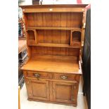 A traditional oak dresser and rack, of recent manufacture, the rack with shelves and two drawers,