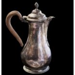 An Edwardian silver small coffee pot or hot water jug, of baluster form, engraved with a crest,