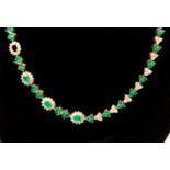 A diamond and emerald cluster 18ct yellow gold line necklace,