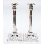 A pair of George III silver candlesticks, detachable floral shaped sconces with beaded rims,