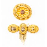 Two Victorian brooches, one set with rubies and diamond to the centre, decorative floral border,