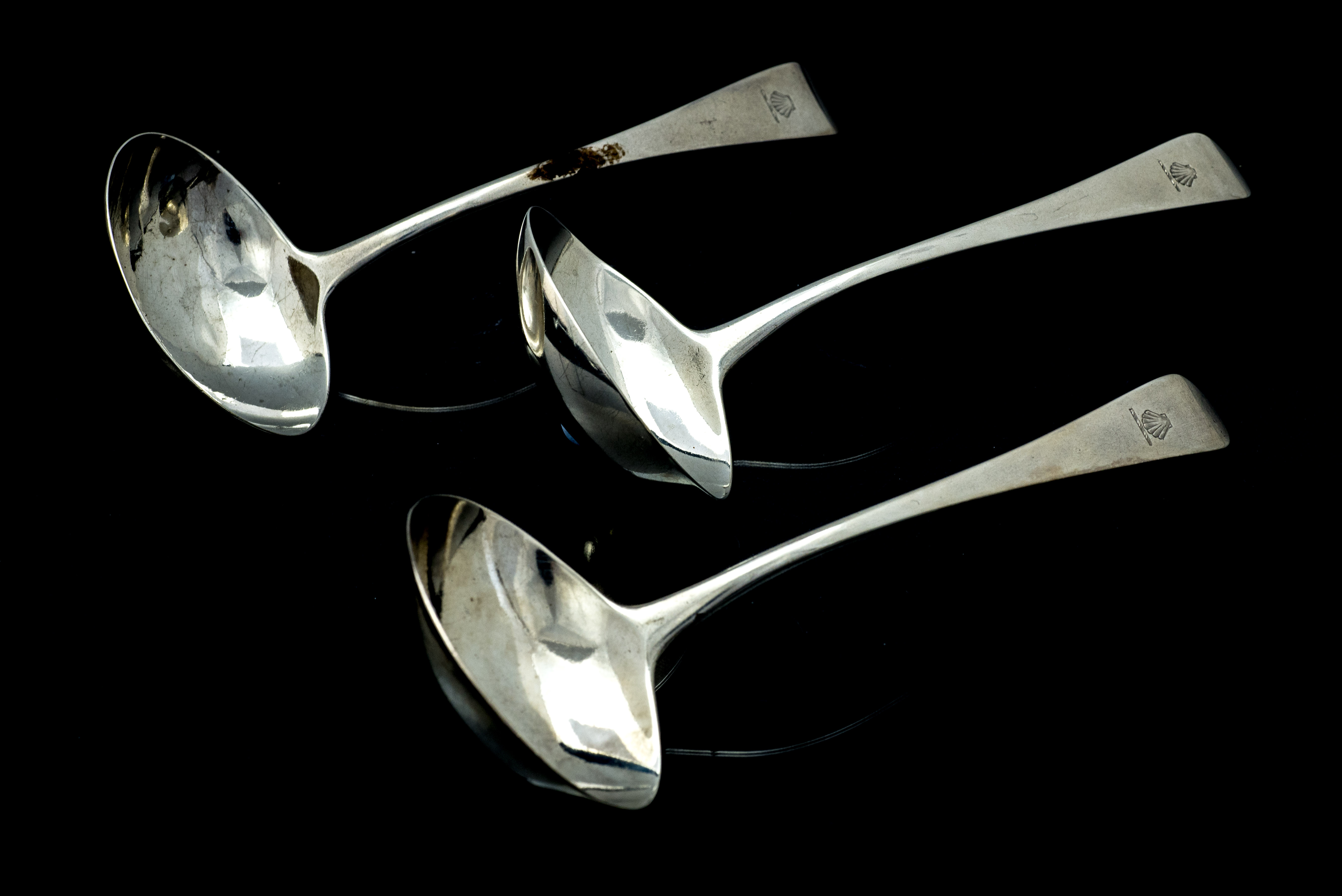 A matched set of three Old English Pattern silver sauce ladles, each handle engraved with a crest,