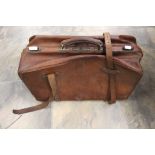 A tan leather Gladstone bag