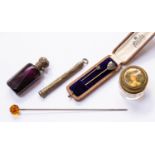 A white metal capped amethyst perfume bottle with stopper, two stick pins in a case,