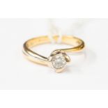 A diamond solitaire, cross over set in two tone 18ct gold, diamond weight 0.
