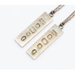 Two silver ingot pendants on chains,