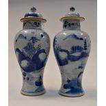 A pair of Chinese blue and white vases and covers painted with typical landscapes,