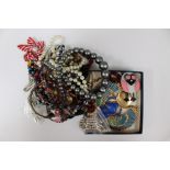 A bag of costume jewellery to include a Victorian paste set yellow metal brooch,