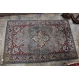 A hand knotted woolen rug on a duck egg blue ground with cream ,