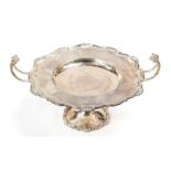 A George V silver twin handled tazza, shaped circular with shell and scroll border,