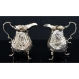 Two George III silver cream jugs, each of baluster form on three shell and scroll trefoil feet,