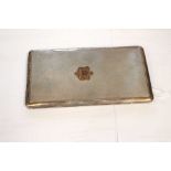 A George VI silver cigarette case, Birmingham 1943, the front bearing a raised bronze armorial,