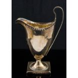 A George III silver cream jug, London 1794, of pedestal Neoclassical helmet form, on square base,