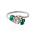 A diamond and emerald platinum three-stone cross-over ring,