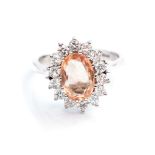 A topaz and diamond 18ct white gold cluster ring, the central oval-cut topaz approx 10mm x 7mm,
