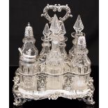 An early Victorian silver seven bottle cruet stand with various glass bottles,