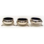 Three matched mid 18th Century silver plain circular salts raised rim on three stylised shell and