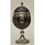 An 18th Century style white metal mounted carved coconut and cover,