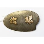 A Canadian silver brooch, etched detail with applied 18ct gold overlaid maple leaves,