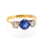 A diamond and sapphire three-stone ring, the central round swiss-cut blue sapphire approx 1.