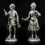 A pair of late 20th century silver figures of a man and woman in 18th century costume, solid cast,