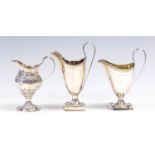 A George III silver helmet shaped cream jug, beaded rim with C-scroll handle on square shaped base,