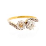 A diamond two-stone cross over ring, diamond set shoulders,