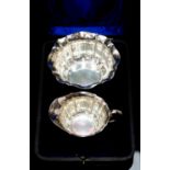 An Edwardian silver strawberry bowl and cream jug, plain bodies with wavy rim and sectioned bodies,