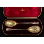 A pair of Victorian silver-gilt ornate serving spoons, shaped bowls with engraved decoration,
