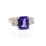 A tanzanite and diamond three-stone platinum ring, the step-cut tanzanite approx 4.