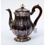 A George IV silver tea pot, the body of lobed baluster form, engraved with a coat of arms,